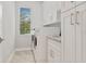 Bright laundry room with white cabinets, washer, and dryer at 1228 Eppinger Dr, Port Charlotte, FL 33953