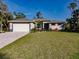 Newly constructed home featuring a white garage door and neat landscaping at 14422 Chamberlain Blvd, Port Charlotte, FL 33953