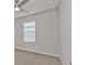 A bright bedroom offers natural light from a window, a ceiling fan, and neutral carpet at 16031 Alcira Cir, Punta Gorda, FL 33955