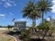 Inviting entrance to 'Burnt Store Village' featuring lush landscaping, palm trees, and an American flag at 16031 Alcira Cir, Punta Gorda, FL 33955