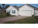 A well-maintained home features a brick driveway, complementing the attached two-car garage and manicured lawn at 16031 Alcira Cir, Punta Gorda, FL 33955