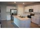 Modern kitchen featuring an island with a sink, stainless steel appliances, and ample white cabinetry at 16031 Alcira Cir, Punta Gorda, FL 33955