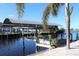 Covered boat lift with dock and tropical landscaping at 193 N Waterway Nw Dr, Port Charlotte, FL 33952