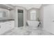 Modern bathroom with a soaking tub, walk-in shower, and marble tile at 2100 Cassino Ct, Punta Gorda, FL 33950