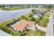 Beautiful aerial view of a lakefront home with a pool, lush landscaping and a brick driveway at 2259 Kenya Ln, Punta Gorda, FL 33983