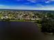 Community view with a picturesque lake, lovely homes, lush greenery and clear skies from above at 2259 Kenya Ln, Punta Gorda, FL 33983