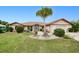 Charming single-story home featuring a mature palm tree and a well-maintained lawn with manicured landscaping at 2259 Kenya Ln, Punta Gorda, FL 33983