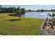 Lakefront property with lush green lawn and a white fence at 2259 Kenya Ln, Punta Gorda, FL 33983