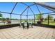 Screened lanai with tiled floor, features a table, chairs, and view of the serene lake beyond at 2259 Kenya Ln, Punta Gorda, FL 33983