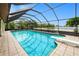 Relaxing screened-in pool area with clear blue water, diving board, and scenic waterfront views at 2259 Kenya Ln, Punta Gorda, FL 33983