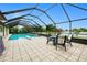 Inviting screened-in pool area with dining area and a scenic view of the backyard at 2259 Kenya Ln, Punta Gorda, FL 33983