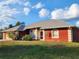 Red house with gray roof, attached garage, and landscaped lawn at 23104 Rountree Ave, Port Charlotte, FL 33980