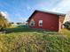 Red house exterior with large window and grassy backyard at 23104 Rountree Ave, Port Charlotte, FL 33980