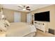 Bedroom with king-size bed, large TV, and ceiling fan at 24 Oakland Hills Ct, Rotonda West, FL 33947