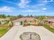 Single-story home with a large driveway and landscaped yard at 24 Oakland Hills Ct, Rotonda West, FL 33947