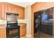Modern kitchen with wood cabinets and black appliances at 24 Oakland Hills Ct, Rotonda West, FL 33947