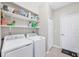 Bright laundry room with washer, dryer, and ample shelving at 25000 Purple Emperor Way, Punta Gorda, FL 33955