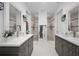 Well-lit bathroom with double vanities, marble floors, stylish mirrors with sconces, and two walk-in showers at 2750 W Marion Ave, Punta Gorda, FL 33950