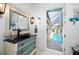 Nautical themed powder room featuring a custom vanity and mirror with access to the pool at 2750 W Marion Ave, Punta Gorda, FL 33950
