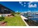 Waterfront backyard featuring a private boat dock, lift, and grassy area leading to screened lanai at 2750 W Marion Ave, Punta Gorda, FL 33950