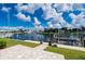 Canal-front home featuring a private dock, grassy lawn, and beautiful landscaping at 2750 W Marion Ave, Punta Gorda, FL 33950