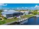 Rear exterior view of pool home with private boat dock and lift on waterfront canal; blue skies in beautiful neighborhood at 2750 W Marion Ave, Punta Gorda, FL 33950