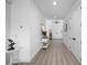Light and airy hallway with wood-look floors, white walls, and stylish decor leading to the home's entrance at 2750 W Marion Ave, Punta Gorda, FL 33950