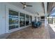 The covered patio features ceiling fans, a large outdoor table, and sliding glass doors at 2750 W Marion Ave, Punta Gorda, FL 33950