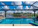 Stunning view of backyard pool and canal with screen enclosure and beautiful landscaping at 2750 W Marion Ave, Punta Gorda, FL 33950
