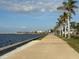 Scenic walkway alongside the water featuring lush palm trees and a clear view of the sky at 2750 W Marion Ave, Punta Gorda, FL 33950