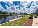 Beautiful waterfront view showcasing lush landscaping, seawall, dock, and canal access at 2750 W Marion Ave, Punta Gorda, FL 33950