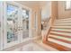 Bright entryway with double doors opening to a courtyard and elegant staircase at 3324 Antigua Dr, Punta Gorda, FL 33950