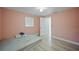 Simple bedroom with light pink walls, a twin bed, and laminate wood flooring at 3355 Elkcam Blvd, Port Charlotte, FL 33952