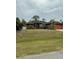One-story home with dark gray exterior, red accents, and a spacious lawn at 5188 Balmor Ter, North Port, FL 34288