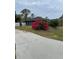 Home with a landscaped yard, featuring a long driveway and bright flowers at 5188 Balmor Ter, North Port, FL 34288
