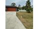 Attached garage with an orange door and a long driveway at 5188 Balmor Ter, North Port, FL 34288