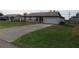 Front view of a house with a driveway and landscaping at 1073 Marcus St, Port Charlotte, FL 33952