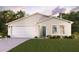 Two-car garage, light beige exterior, and a well-manicured lawn at 12499 Killian St, Spring Hill, FL 34609