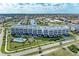 Stunning aerial view of a modern condo building with a pool, lush landscaping, and surrounding neighborhood at 1425 Park Beach Cir # 149, Punta Gorda, FL 33950
