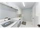 Modern laundry room with white cabinets, sink, and new front-loading washer and dryer at 1425 Park Beach Cir # 149, Punta Gorda, FL 33950