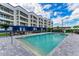 Relax in the pool with clear blue skies, and a view of the condo buildings and pergola at 1425 Park Beach Cir # 149, Punta Gorda, FL 33950