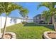 Landscaped backyard with grassy area and screened patio at 15292 Mille Fiore Blvd, Port Charlotte, FL 33953