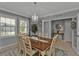 Spacious dining room with a chandelier, wood table and access to entryway at 15292 Mille Fiore Blvd, Port Charlotte, FL 33953