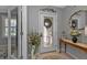 Elegant entryway with a glass-paned door, decorative mirror and console table at 15292 Mille Fiore Blvd, Port Charlotte, FL 33953