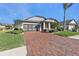 Brick paver driveway leading to a one-story home with a screened-in garage at 15292 Mille Fiore Blvd, Port Charlotte, FL 33953