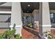 Covered front porch with brick flooring, seating area, and potted plants at 15292 Mille Fiore Blvd, Port Charlotte, FL 33953