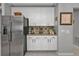 White kitchen cabinets and stainless steel refrigerator at 15292 Mille Fiore Blvd, Port Charlotte, FL 33953