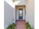 Front entry with a dark wood door and brick walkway at 1656 Hyssop Loop, North Port, FL 34289