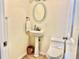 Clean bathroom with pedestal sink, toilet and oval mirror at 1931 Bayshore Dr, Englewood, FL 34223