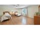 Bright bedroom with two twin beds, hardwood floors, and a ceiling fan at 1931 Bayshore Dr, Englewood, FL 34223